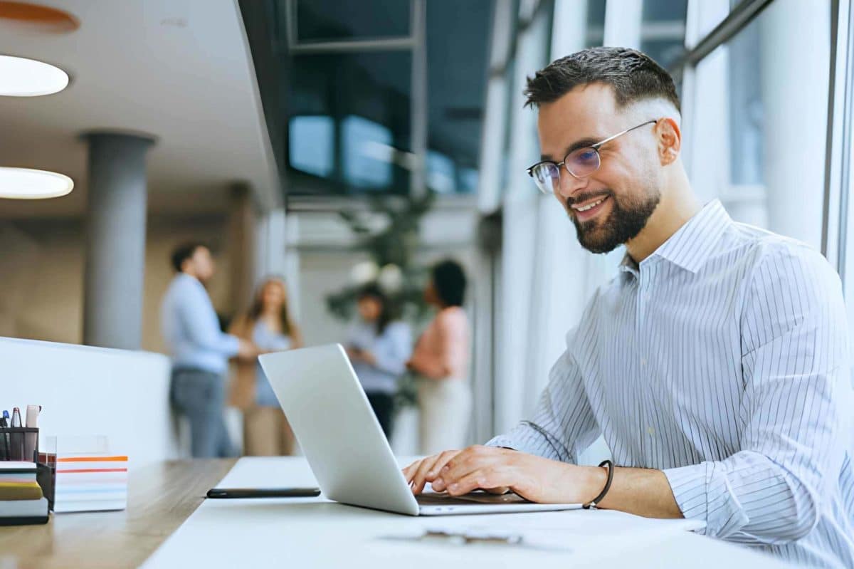 Uomo concentrato che lavora su un computer portatile