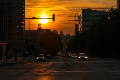 Strada romana sotto il sole intenso con termometro che segna temperature record durante l'allerta caldo