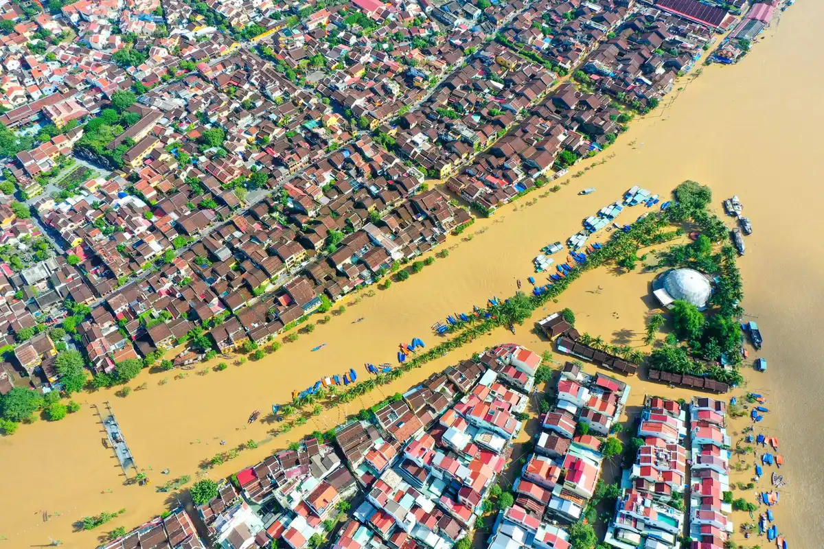 Tecnici e pianificatori urbani studiano mappe e progetti di adattamento climatico in una sala riunioni.