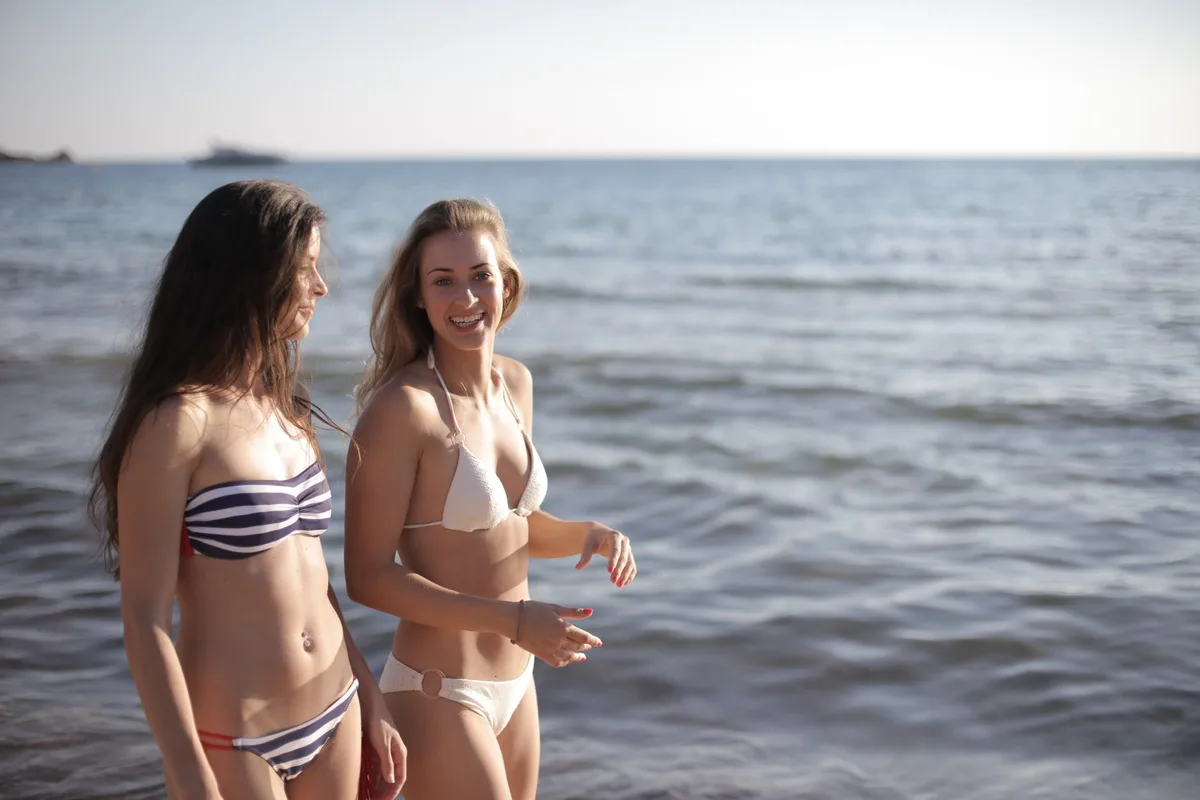 Gruppo di amiche in vacanza al mare con abiti da spiaggia e momenti informali.