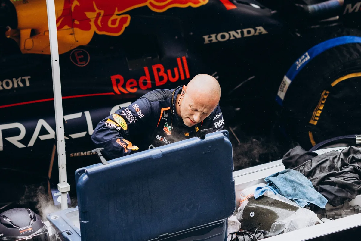 Tecnici di un team di Formula 1 al lavoro intorno a una monoposto durante sessioni tecniche in pista.