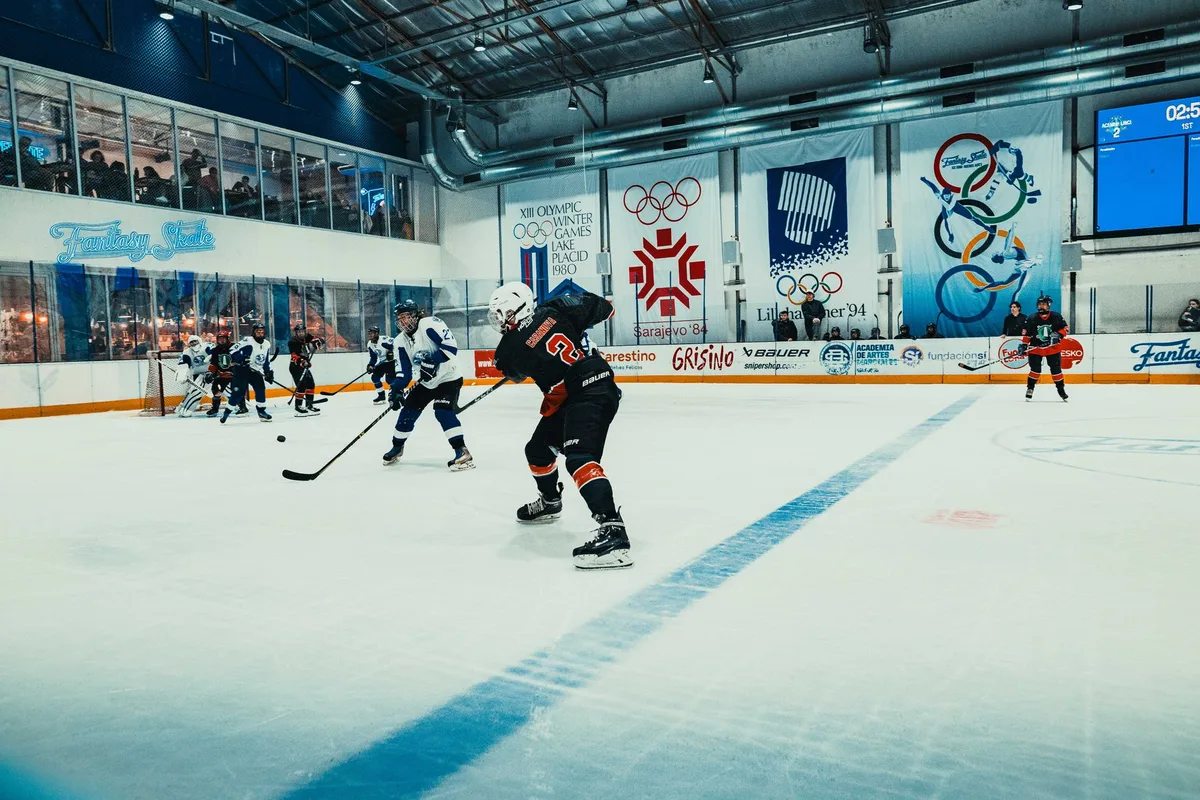 Azione di gioco durante una partita di hockey su ghiaccio femminile con atlete in movimento
