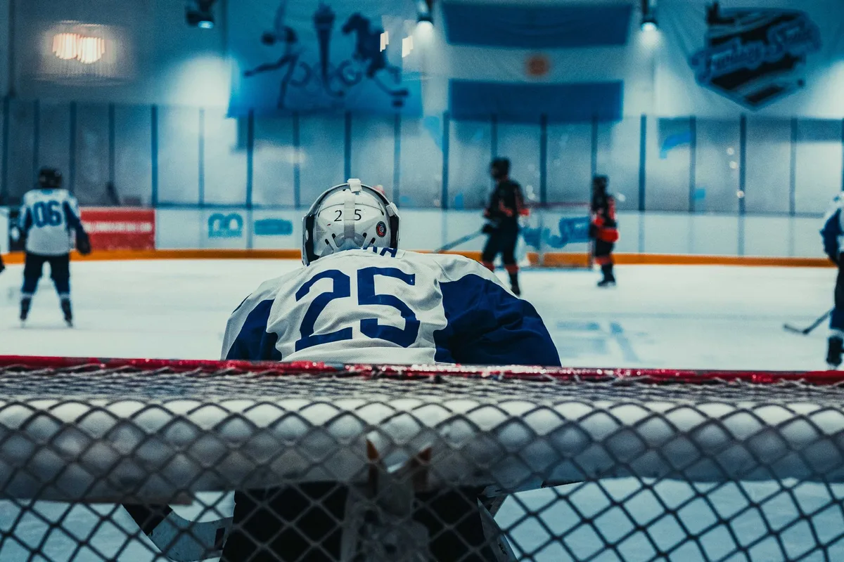Giocatrice di hockey su ghiaccio femminile esegue un tiro verso la porta durante una partita