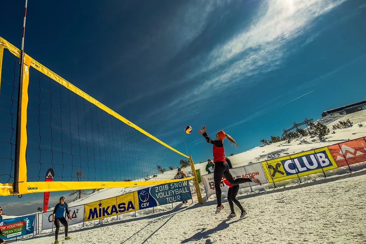 Giocatrice di pallavolo durante uno schiacciata in palestra, braccio alzato e concentrazione massima