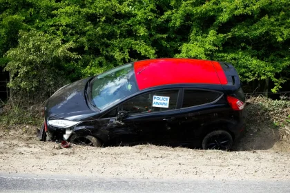 Scena di incidente stradale con veicoli danneggiati e luci di emergenza su strada dipartimentale