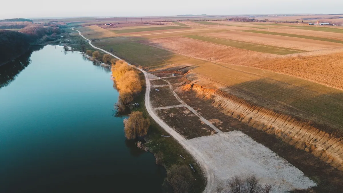Mani di agricoltore con terreno arido e mappa di oleodotto