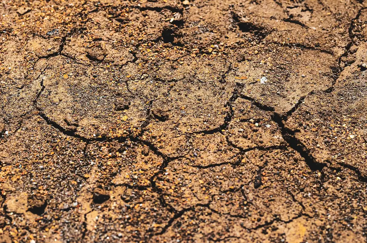 Terreno crepato e impianto di irrigazione secco nei campi