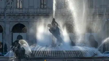 Mani anonime che scambiano volantini su un tavolo in una piazza, atmosfera collaborativa