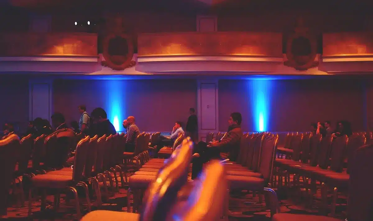 Pubblico anonimo e palcoscenico con proiezioni digitali in sala conferenze