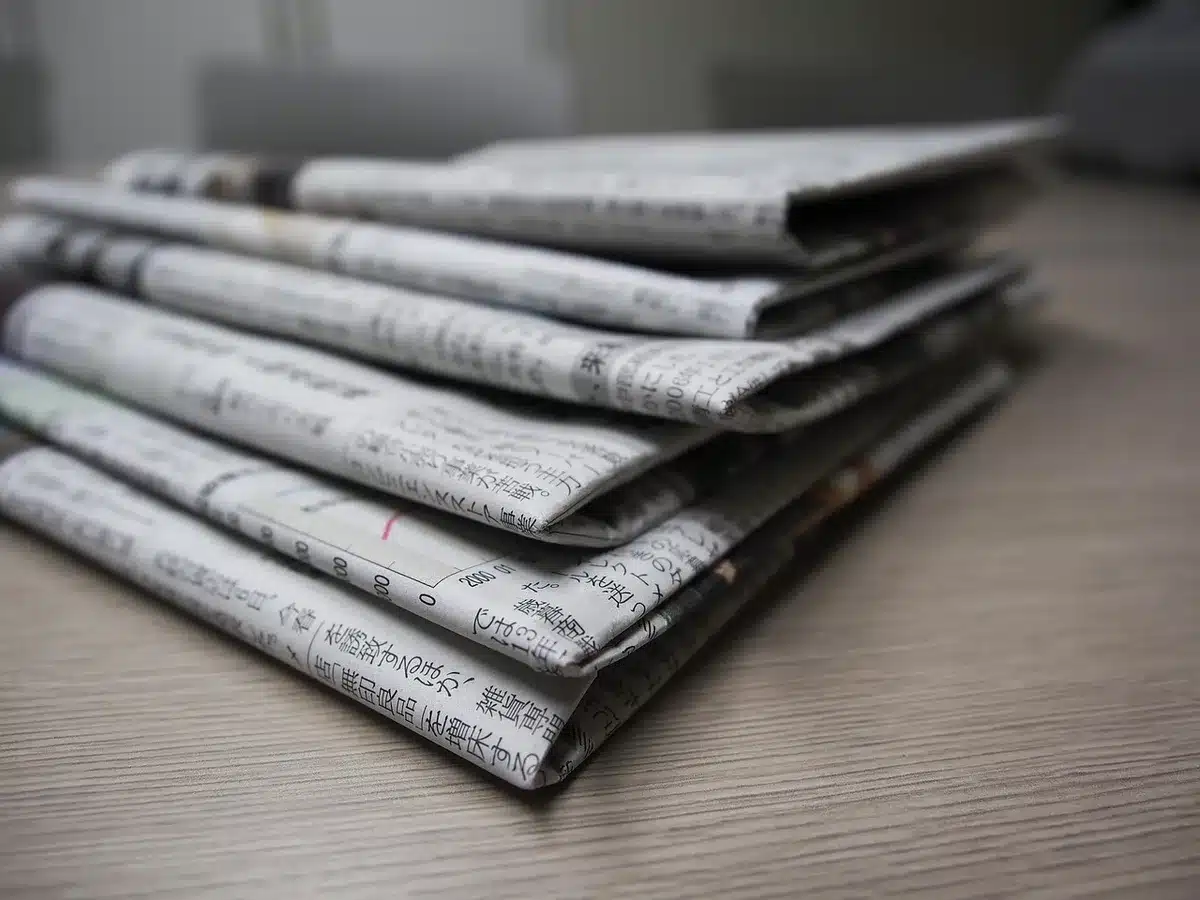 Palinsesto televisivo scritto su fogli e orologio da tavolo