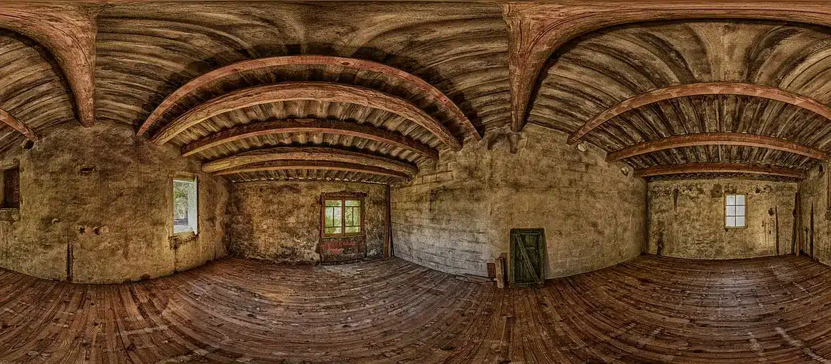 Sala controllo televisiva vuota con monitor spenti e fogli di palinsesto sul tavolo