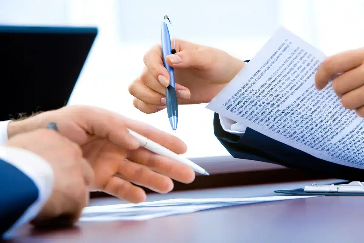 Persone in un dibattito pubblico in una sala civica, microfono e pubblico attento