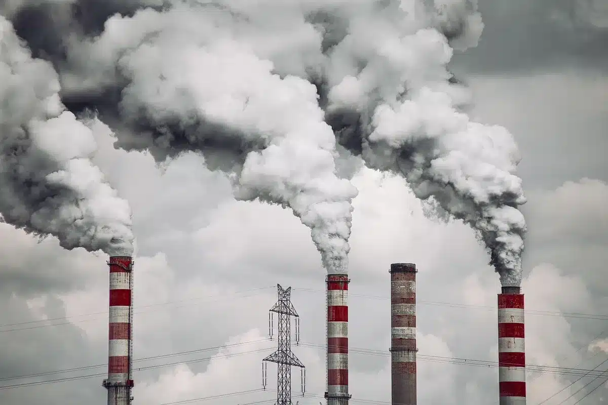 Impianto industriale distrutto con macerie e fiamme residue