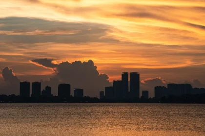 Sagoma anonima davanti a rack di server con skyline della città sullo sfondo