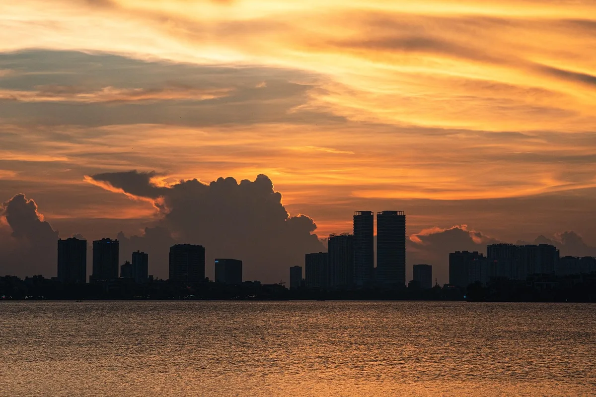Sagoma anonima davanti a rack di server con skyline della città sullo sfondo