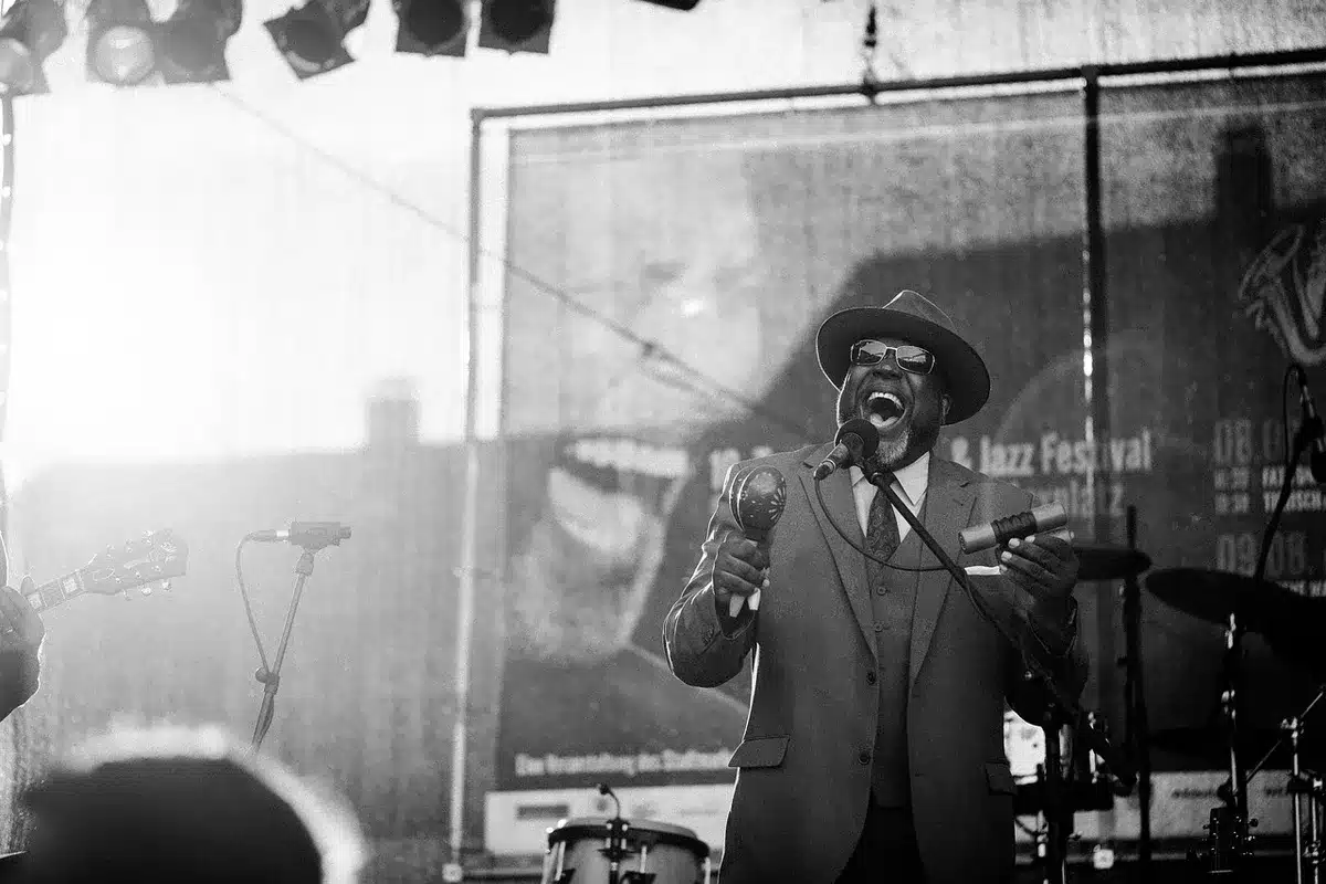 Musicisti jazz esibiti su un palco all'aperto con il pubblico, atmosfera di condivisione culturale