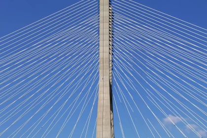 Viadotto cable-stayed con rilevatori e tecnici in lontananza lungo una strada