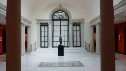 Galleria sotterranea con esedra antica e passerella, ambiente archeologico