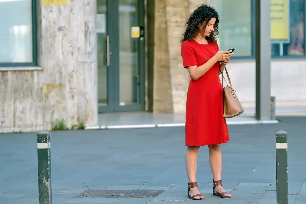 Persona su divano che guarda contenuti in streaming su smartphone