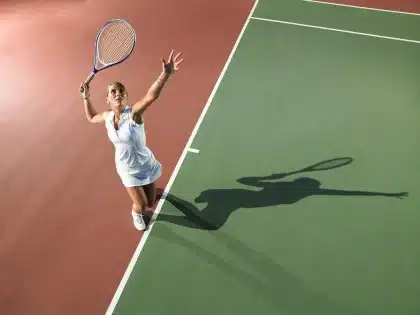 Spettatori in silhouette vicino a racchette e panchina su un campo da tennis all'aperto