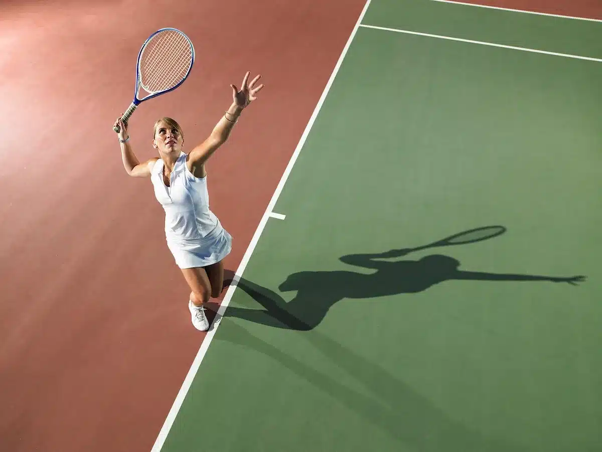 Spettatori in silhouette vicino a racchette e panchina su un campo da tennis all'aperto