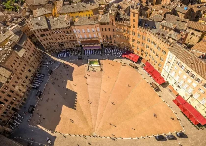 Giovani in pellegrinaggio con candele in piazza alla sera, vista anonima