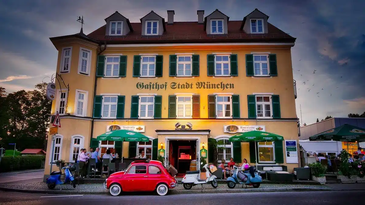 Vicolo con trattoria anonima, panchina e contenitori take-away al tramonto