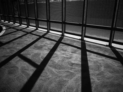 Mani anonime e superfici architettoniche in bianco e nero, luce e ombra nette