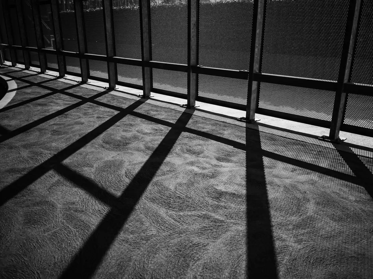 Mani anonime e superfici architettoniche in bianco e nero, luce e ombra nette