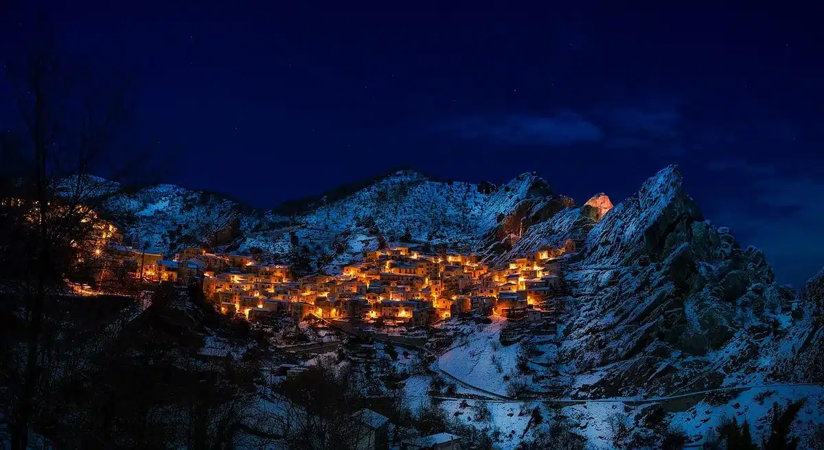 Panorama di borgo collinare con ponte storico e sentieri