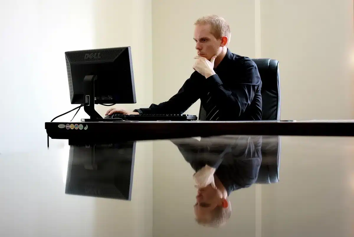Silhouette walking away in a generic newsroom with unbranded monitor