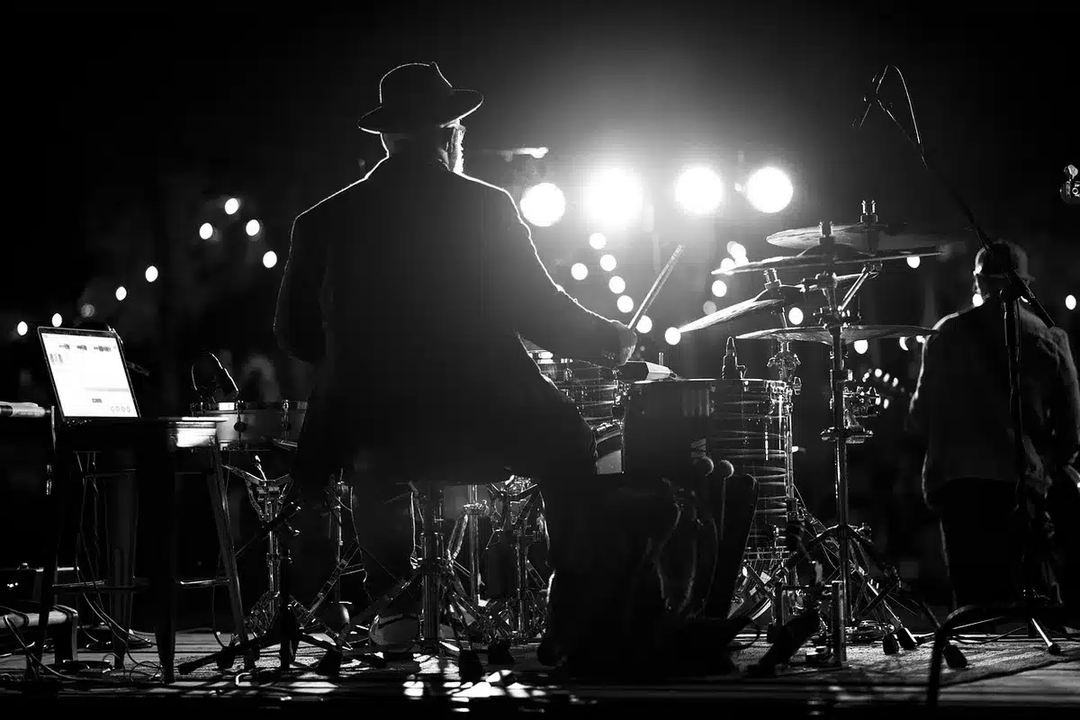 Close-up of a vintage microphone on a stand, spotlight on the mic, empty rows of chairs out of focus — symbolic of audition moments