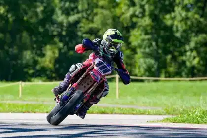 Moto da corsa parcheggiata vicino a una curva del circuito con meccanici in ombra