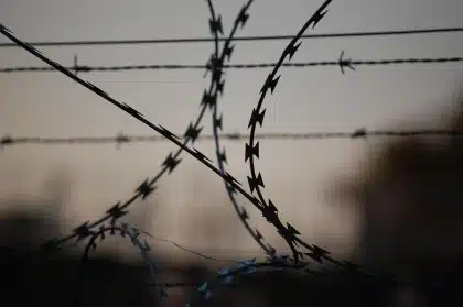 Compounds desert military fence silhouettes evoking detention and secrecy
