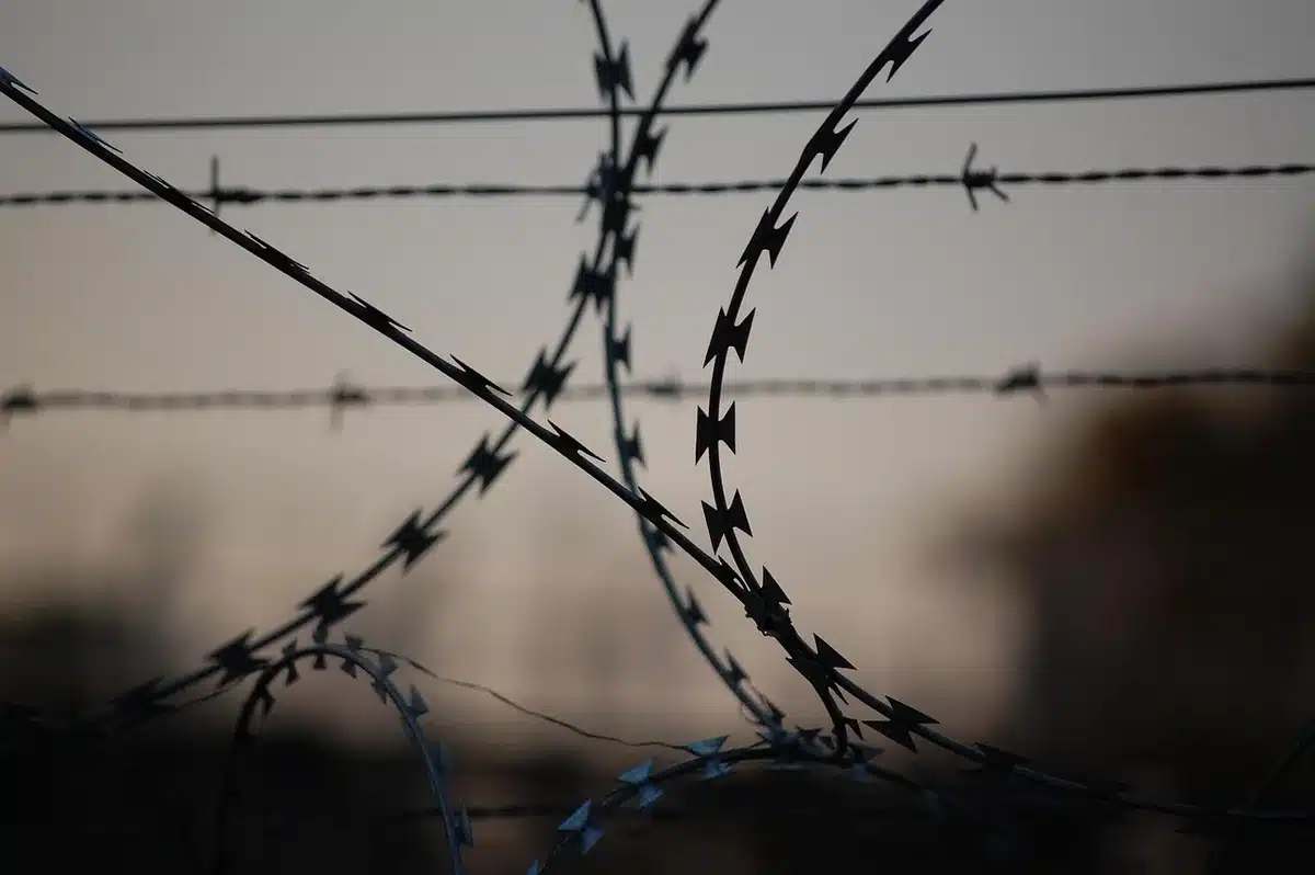 Compounds desert military fence silhouettes evoking detention and secrecy