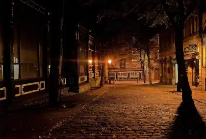 Piazza cittadina vuota con edificio municipale e sagome di passanti sullo sfondo