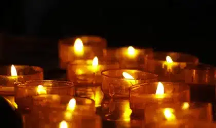 Studenti e sopravvissuti vicino a un piccolo memoriale sulla costa di Lampedusa