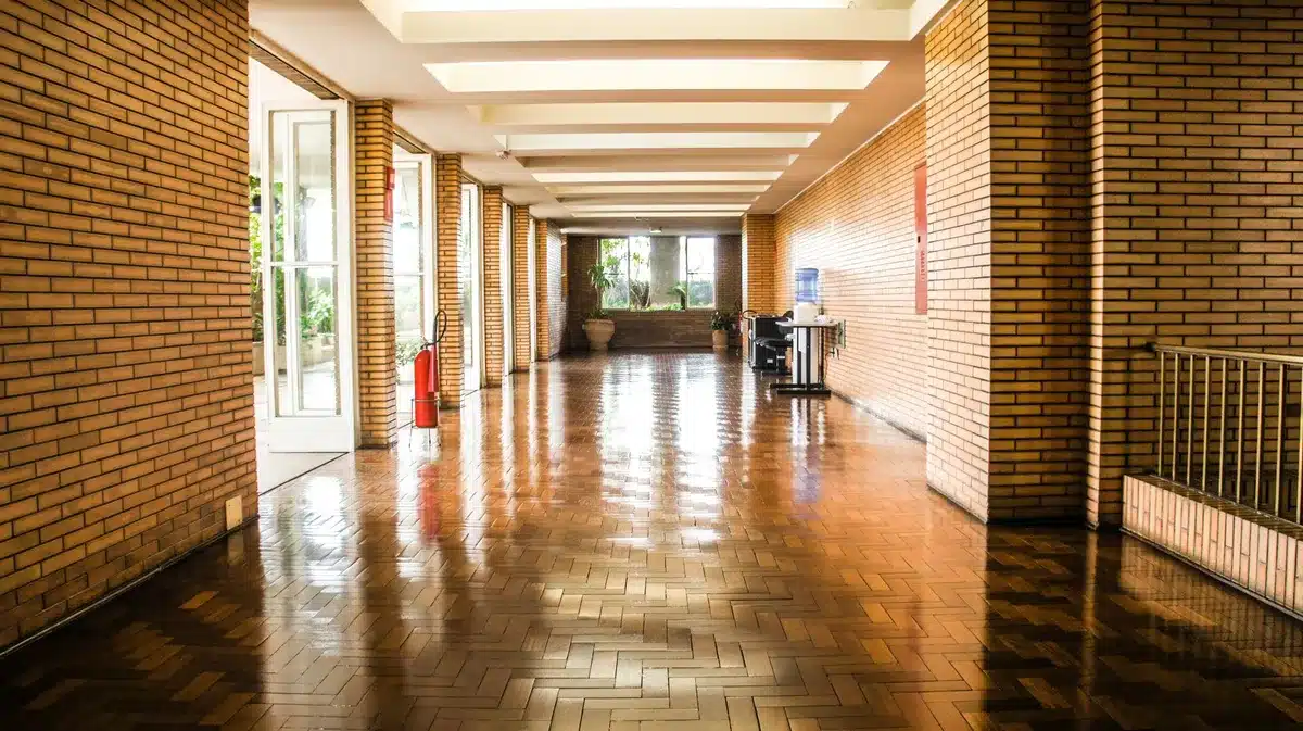 empty university research corridor with anonymous figures, papers on a table and a softly lit notice board